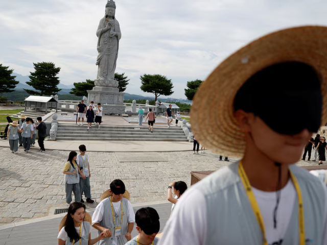 Blindfolded participants take part in a guided walking activity near a Buddhist statue during a temple matchmaking programme at Naksansa temple in Yangyang, South Korea, July 11, 2026. PHOTO: Reuters