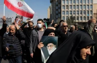 a demonstrator holds an image of iran s late supreme leader ayatollah ali khamenei after he was killed in israeli and us strikes on saturday photo reuters