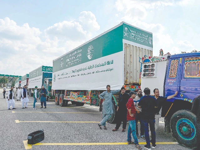 men stand near trucks carrying relief aid donated by the saudi arabian government for flood victims in islamabad photo afp