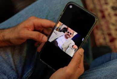 yashib rizwan 33 holds a mobile phone showing a picture of his father captain muhammad rizwan idris 62 the late pilot of the k2 airways boeing 737 cargo aircraft that crashed in the arabian sea during an interview with reuters at his home in karachi pakistan july 16 2026 reuters