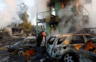 a resident with a dog looks on at the site of private car garages hit by a russian missile strike amid russia s attack on ukraine in kyiv ukraine october 7 2026 photo reuters