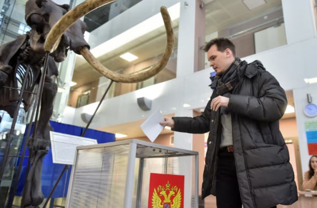 a man casts his ballot near a giant mammoth skeleton at a polling station located in novosibirsk state university on the final day of the presidential election in novosibirsk russia march 17 2024 photo reuters