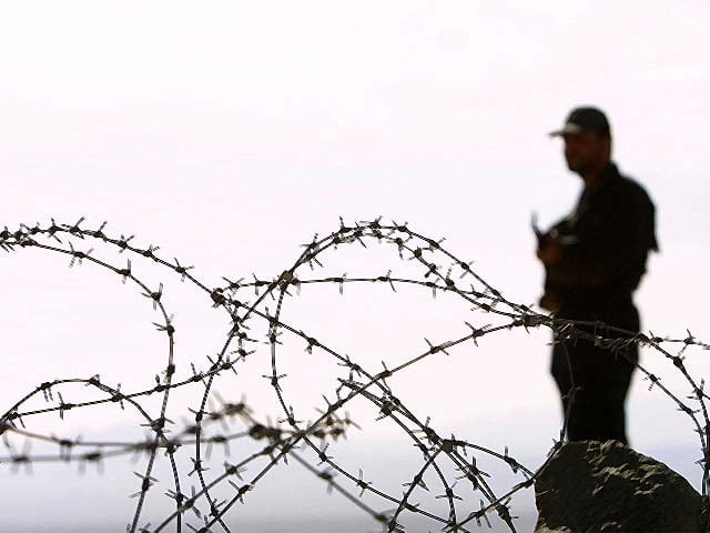 a soldier stands near barbed wire photo afp