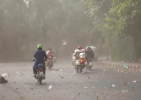 motorcyclists on the way at a road during dust storm before rain in lahore photo online