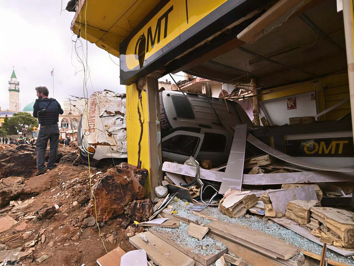This photograph taken during a media tour organized by the Hezbollah shows a photographer standing next to an overturned ambulance at Nabi Sheet town after an Israeli military operation in the Bekaa Valley of Lebanon, on Mar. 7, 2026. PHOTO: AFP