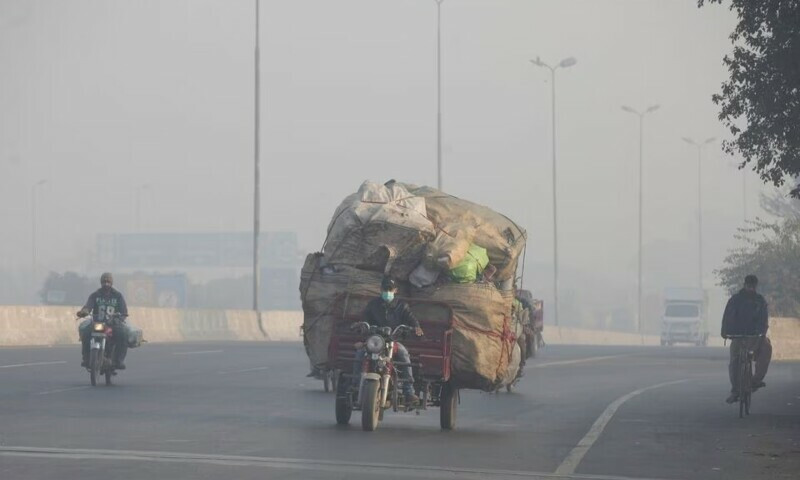 a man rides a motor tricycle loaded with sacks of recyclables amid dense smog in lahore on november 24 2021 photo reuters file