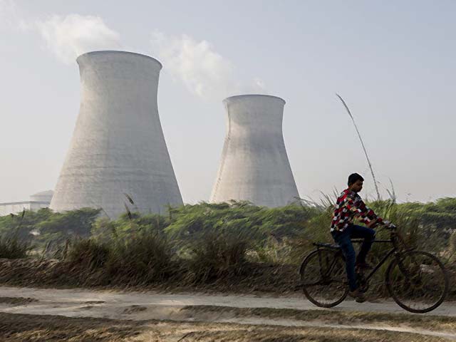 An Indian man cycles along a dirt road next to the Norora Atomic Power Station near Norora in Uttar Pradesh PHOTO AFP