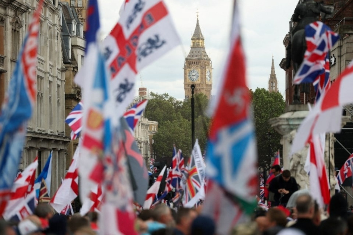 The Elizabeth Tower, commonly known as Big Ben, stands in the background as protesters hold flags during a 