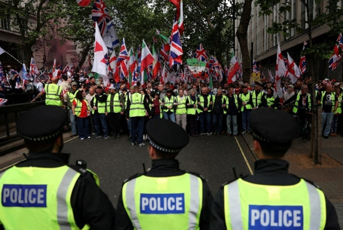 Police officers stand guard as protesters gather on the day of a 