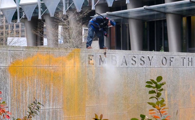 workers clean orange paint sprayed on part of the us embassy in london wednesday photo rueters