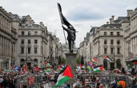 people hold palestinian flags next to a statue depicting a figure carrying a flag covering their face and stepping off a plinth by british street artist banksy during a march held by palestine solidarity campaign to mark the 78th anniversary of the nakba and against the unite the kingdom rally taking place in london organised by british anti immigration activist stephen yaxley lennon also known as tommy robinson in london britain may 16 2026 reuters
