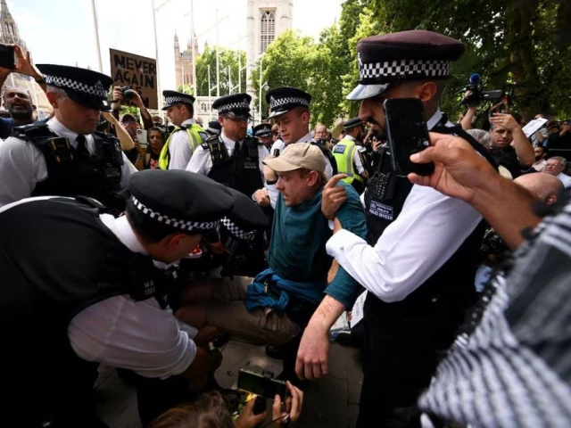 police officers detain a demonstrator during a rally organised by defend our juries challenging the british government s proscription of palestine action under anti terrorism laws in parliament square in london britain august 9 2025 photo reuters police officers detain a demonstrator during a rally organised by defend our juries challenging the british government s proscription of palestine action under anti terrorism laws in parliament square in london britain august 9 2025 photo reuters