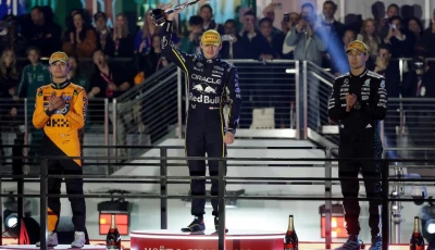 red bull s max verstappen celebrates on the podium after winning the las vegas grand prix along with second placed mclaren s lando norris and third placed mercedes george russell photo reuters