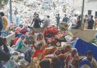 families anxiously wait for a word on their loved ones amid the rubble of the collapsed building in karachi photo afp
