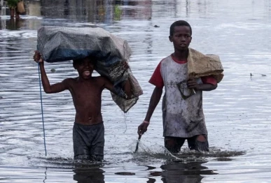 children wade through a flooded street after cyclone gezani tore through the port city of toamasina madagascar february 12 photo reuters