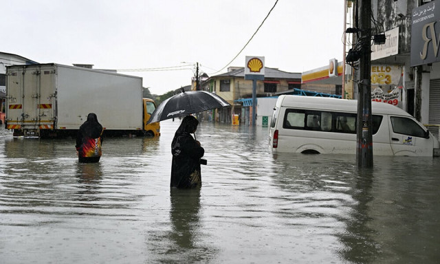 a woman looks at a submerged vehicle during heavy rain in pasir puteh in malaysia s kelantan state on november 30 2024 photo afp a woman looks at a submerged vehicle during heavy rain in pasir puteh in malaysia s kelantan state on november 30 2024 photo afp