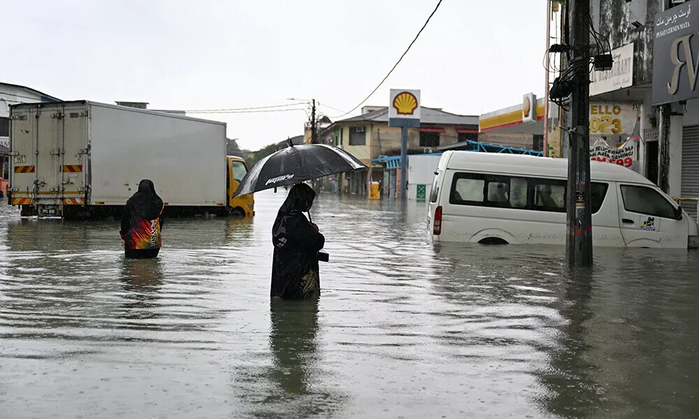 a woman looks at a submerged vehicle during heavy rain in pasir puteh in malaysia s kelantan state on november 30 2024 photo afp a woman looks at a submerged vehicle during heavy rain in pasir puteh in malaysia s kelantan state on november 30 2024 photo afp