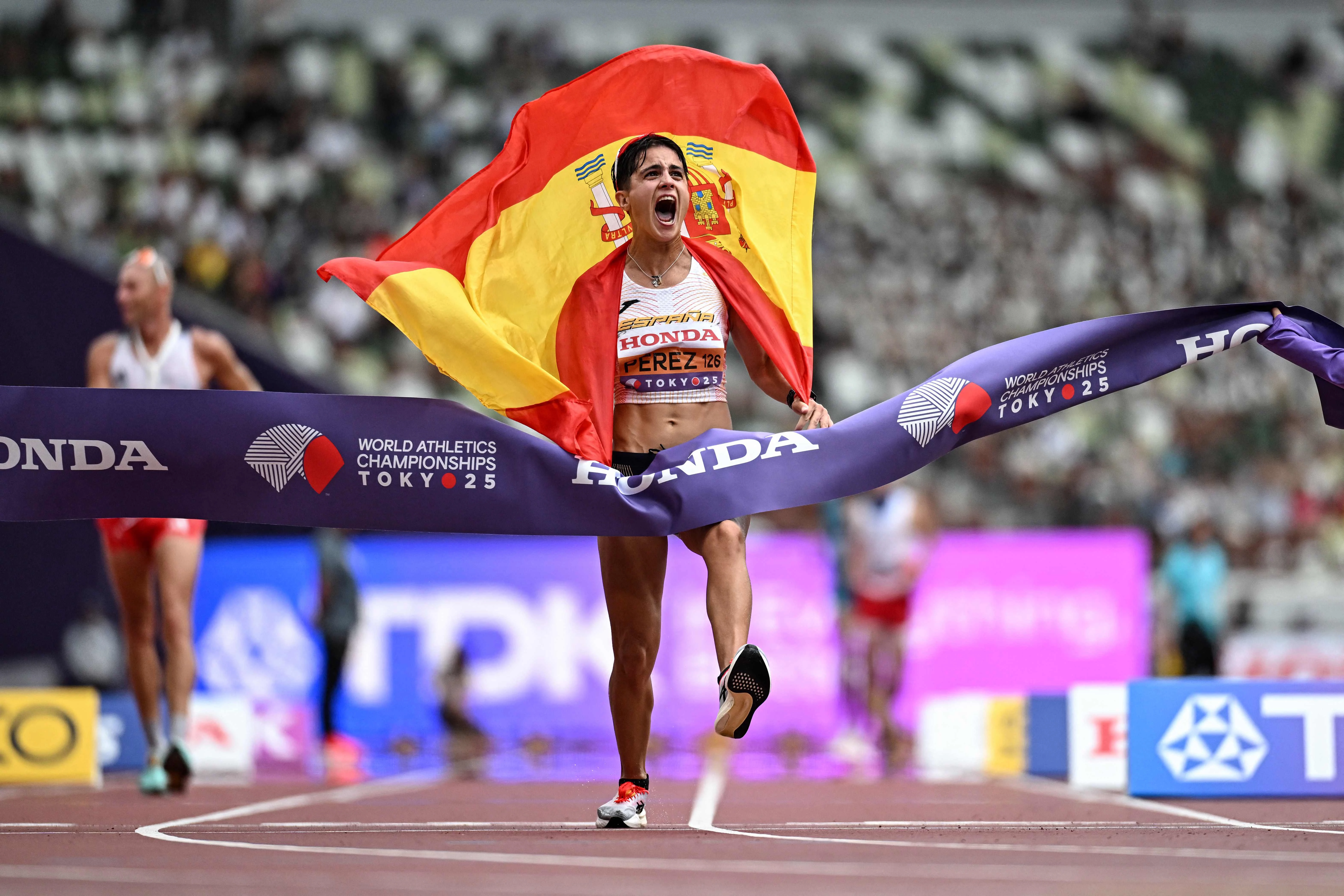 spain s maria perez celebrates as she crosses the finish line to win the women s 35km race walk final during the world athletics championships in tokyo on september 13 2025 photo afp