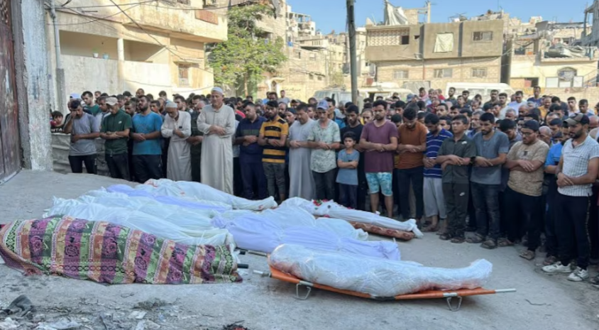 Palestinians pray next to the bodies of Palestinians killed in an Israeli strike on a school sheltering displaced people, amid the Israel-Hamas conflict, in Gaza City, August 10, 2024. PHOTO: REUTERS