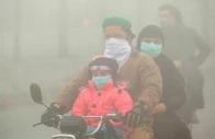 people use face masks to protect themselves from morning smog as they ride on bike along a road in lahore photo reuters
