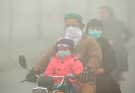 people use face masks to protect themselves from morning smog as they ride on bike along a road in lahore photo reuters people use face masks to protect themselves from morning smog as they ride on bike along a road in lahore photo reuters