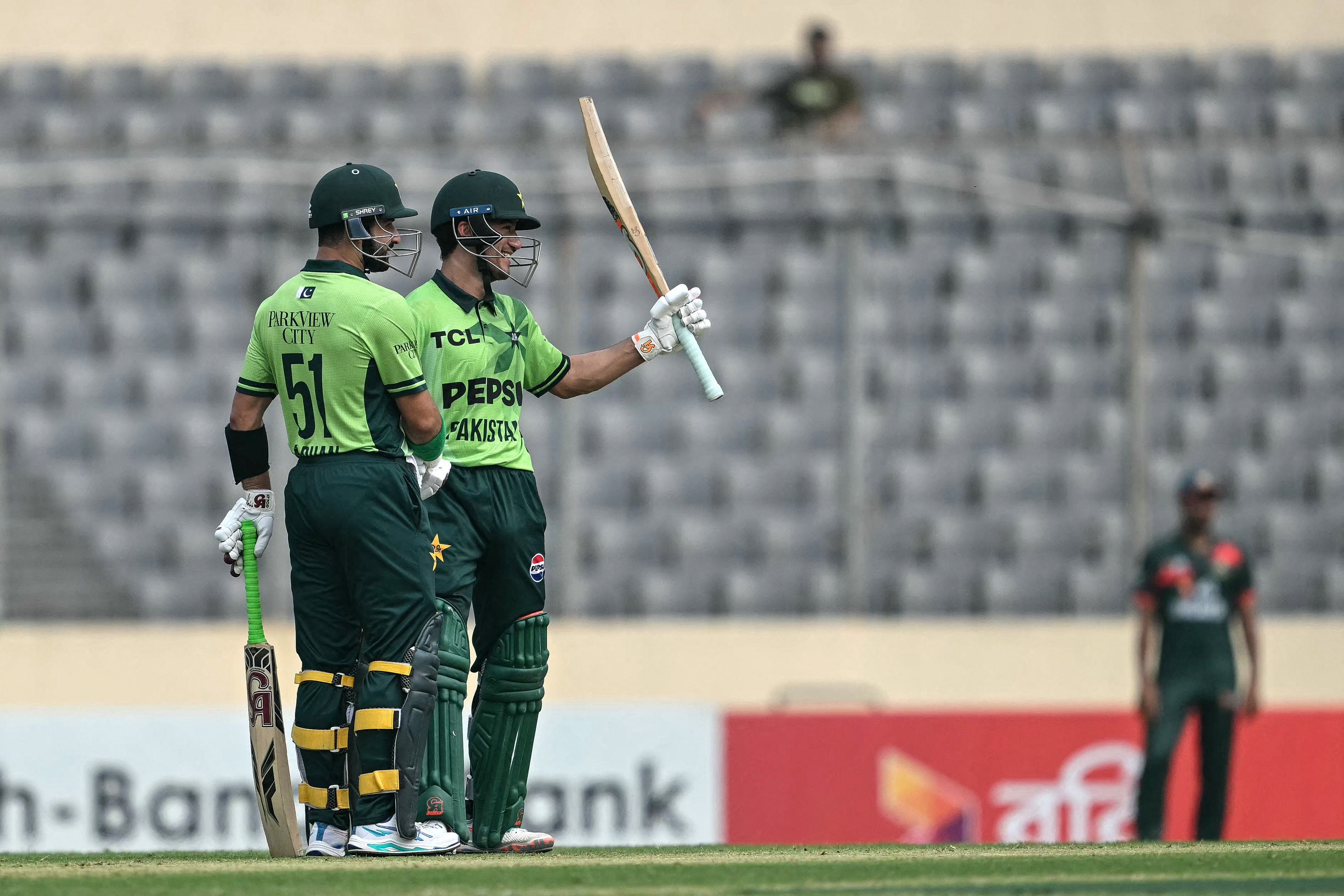 Pakistan's Maaz Sadaqat (2L) celebrates after scoring a half-century (50 runs) as Pakistan's Sahibzada Farhan (L) watches during the second one-day international (ODI) cricket match between Bangladesh and Pakistan at Sher-e-Bangla National Stadium in Mirpur on March 13, 2026. Photo: AFP