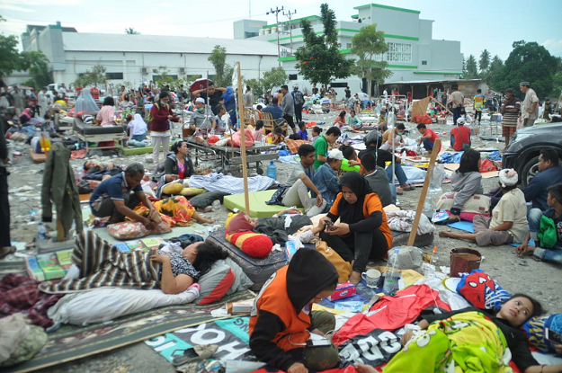 Medical team members help patients outside a hospital AFP