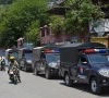 commuters ride past security personnel as they patrol a street ahead of a protest by the banned jaac in muzaffarabad capital of azad jammu and kashmir on june 7 2026 photo afp