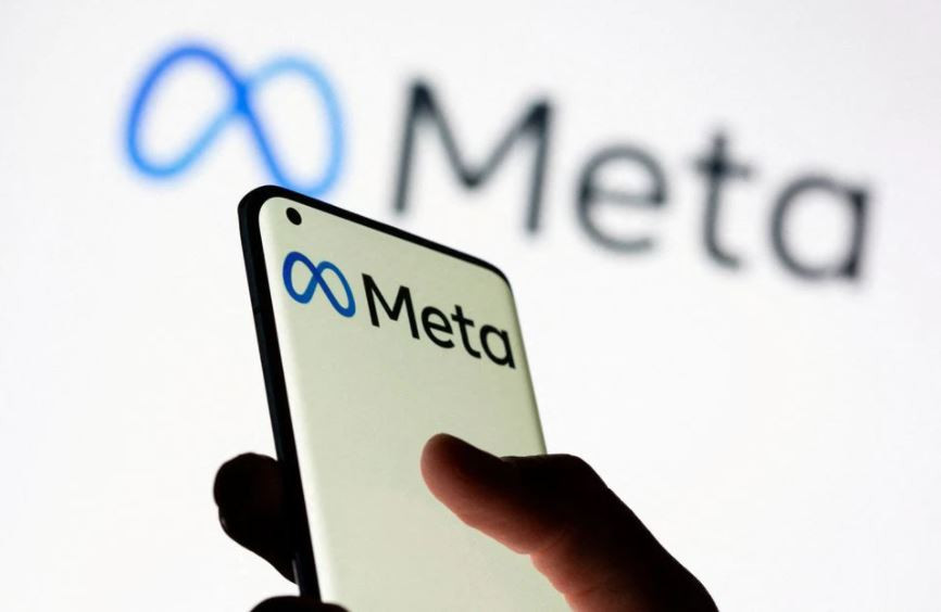 woman holds smartphone with meta logo in front of a displayed facebook s new rebrand logo meta in this illustration picture taken october 28 2021 photo reuters file