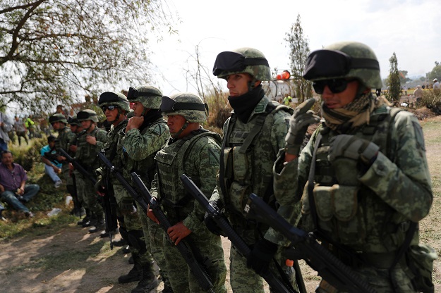 Soldiers keep watch at the site where a fuel pipeline ruptured by suspected oil thieves exploded, in the municipality of Tlahuelilpan, state of Hidalgo, Mexico January 19, 2019. PHOTO: REUTERS 