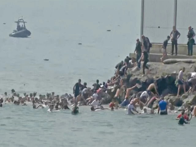 by sea migrants swim through spain s ceuta border from the moroccan side and climb onto rocks to reach the border fence in ceuta spain photo reuters by sea migrants swim through spain s ceuta border from the moroccan side and climb onto rocks to reach the border fence in ceuta spain photo reuters