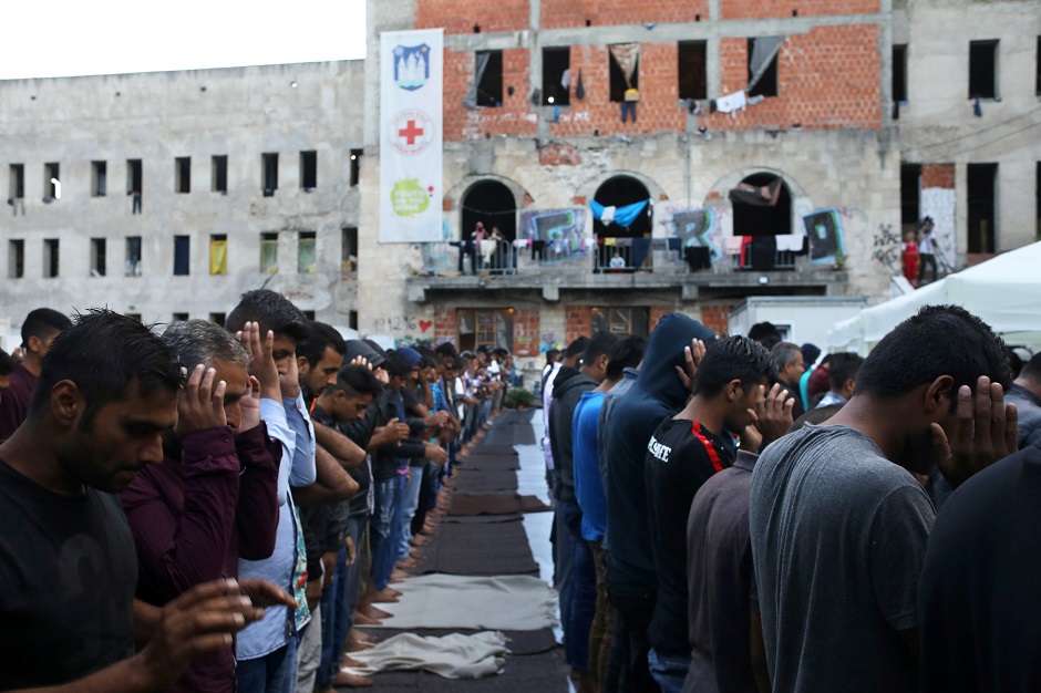 Migrants pray during Eidul Azha in front of a dorm destroyed during the Bosnian war in Bihac, Bosnia and Herzegovina on August 21, 2018. PHOTO:REUTERS