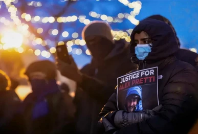 people mourn at a makeshift memorial in the area where 37 year old alex pretti was shot dead by federal immigration agents earlier in the day in minneapolis minnesota on january 24 2026 photo afp
