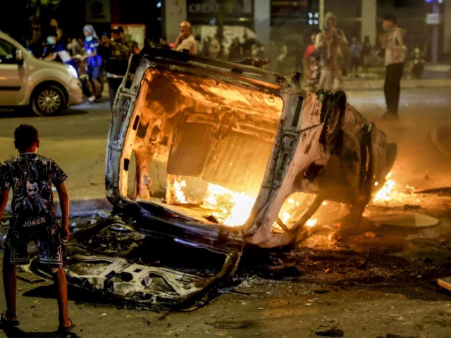 a boy looks at a police vehicle set on fire during a youth led demonstration demanding reforms in the healthcare and education sectors in sale on october 1 2025 photo afp