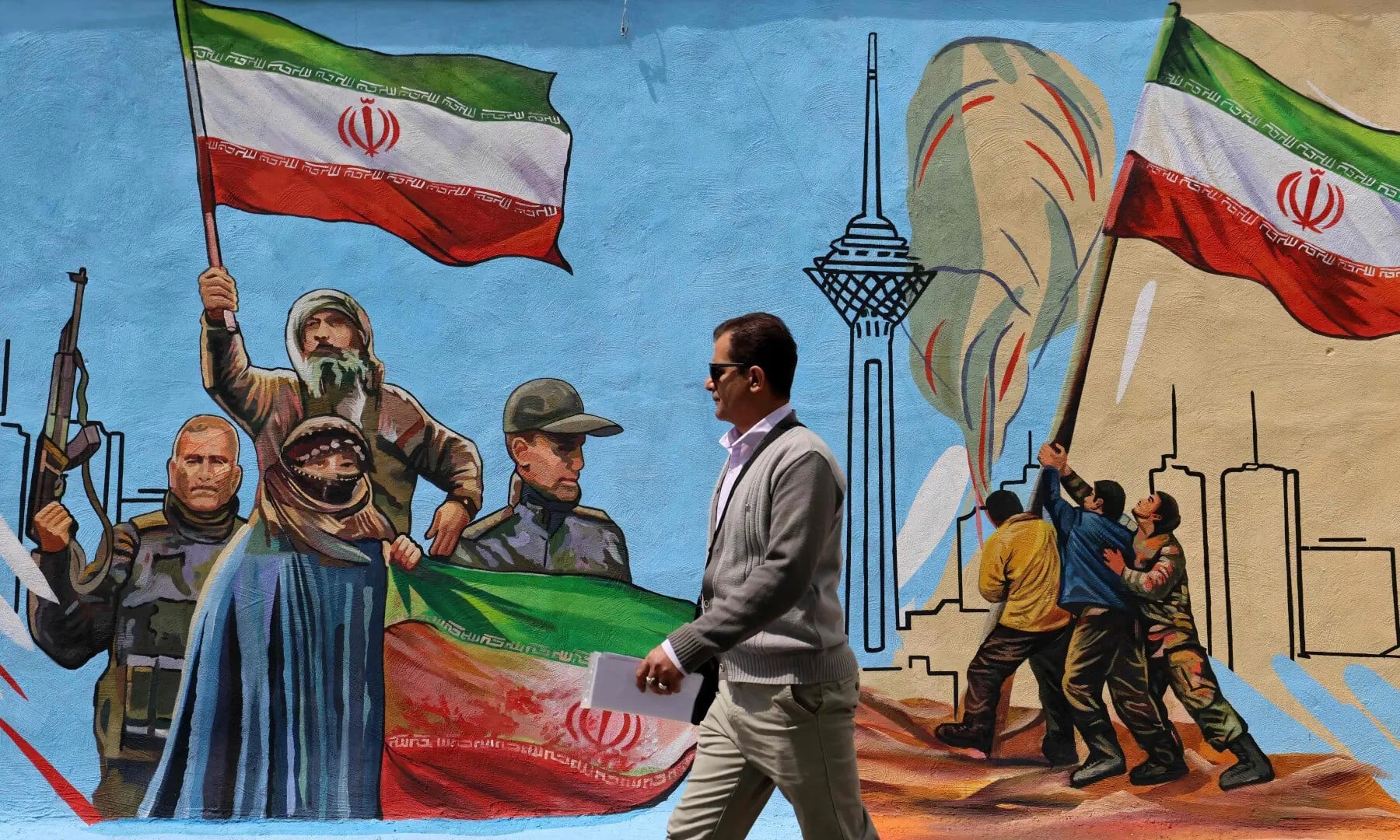 This photo taken on April 8, 2026 shows a man walking past an anti-USA and anti-Israel mural, in Tehran. — AFP/File