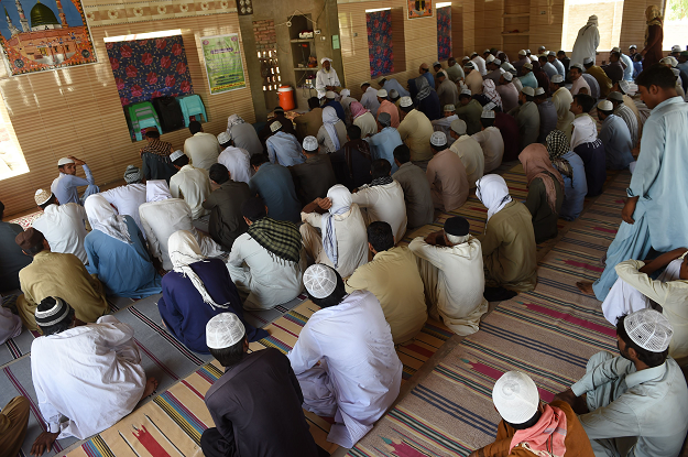 Muslims listen to Allah Jurio, the Imam of a local mosque. PHOTO: AFP