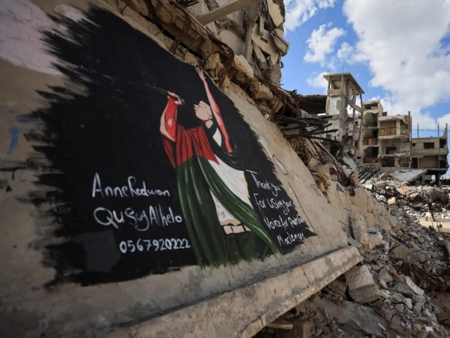 palestinians walk near a mural painted in honour of american rapper macklemore amid buildings destroyed during the war in gaza city september 18 2026 photo reuters palestinians walk near a mural painted in honour of american rapper macklemore amid buildings destroyed during the war in gaza city september 18 2026 photo reuters