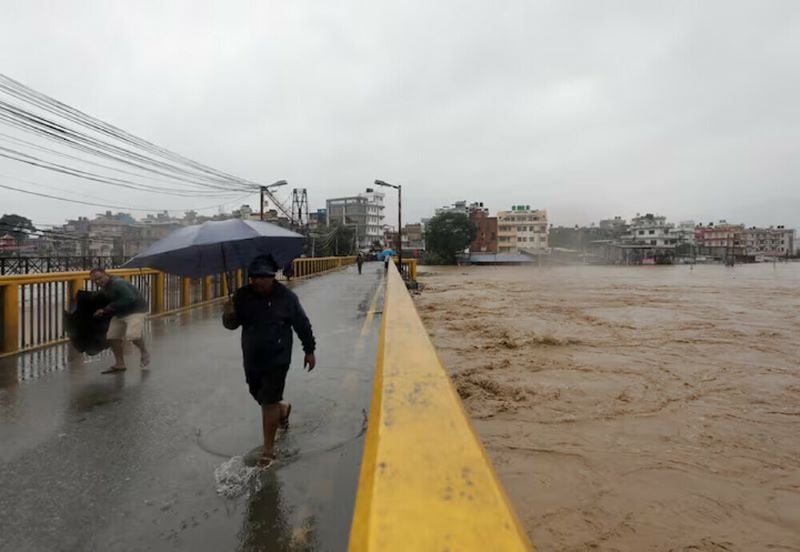 people cross the bridge amid the overflowing bagmati river following heavy rains in kathmandu nepal september 28 2024 photo reuters