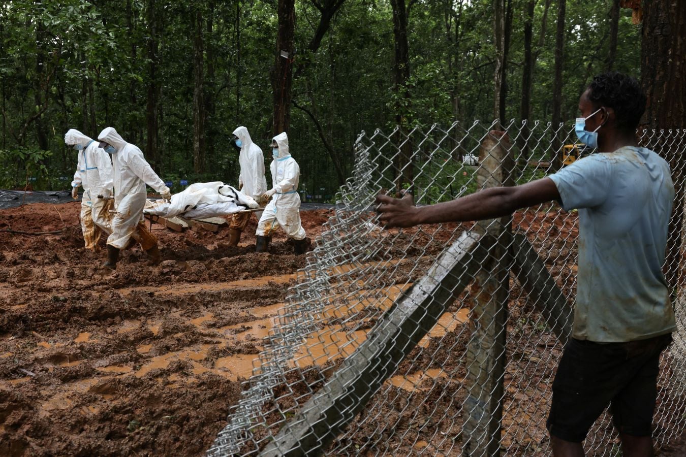 Armed Police Force (APF) officers transport a body to the pit at Devghat mass burial site for victims of deadly flash floods and mudslides in Chitwan, Nepal, September 1, 2026. REUTERS