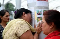 a woman whose son is missing reacts next to photographs of missing people pasted on a pillar outside tribhuvan university teaching hospital following flash floods and a mudslide in kathmandu nepal september 1 2026 reuters