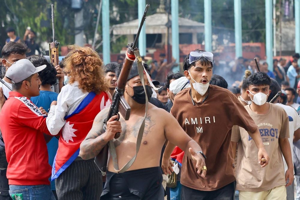 A protester carries a firearm as demonstrators gather outside the Singha Durbar palace complex during a protest to condemn the police's deadly crackdown on demonstrators in Kathmandu on September 9, 2025.PHOTO:AFP