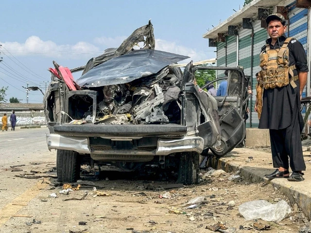 a security personnel stands guard beside the wreckage of a vehicle after a blast in bajaur khyber pakhtunkhwa province on july 2 2025 photo afp