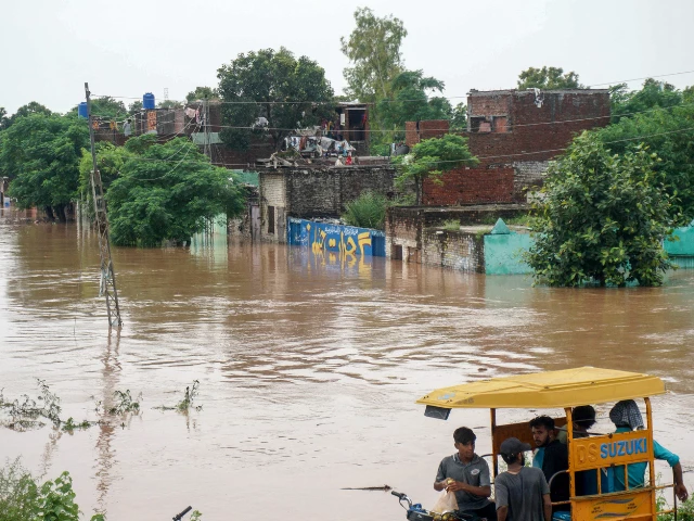 commuters ride in a rickshaw through a flooded area of wazirabad a town in punjab province on august 27 2025 photo afp