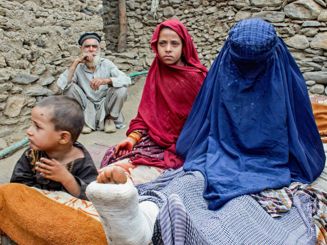 An Afghan burqa-clad woman with an injured leg sits beside children outside a house, in the aftermath of an earthquake at the Dara-i-Nur district of Nangarhar province on September 3, 2025. Photo: AFP