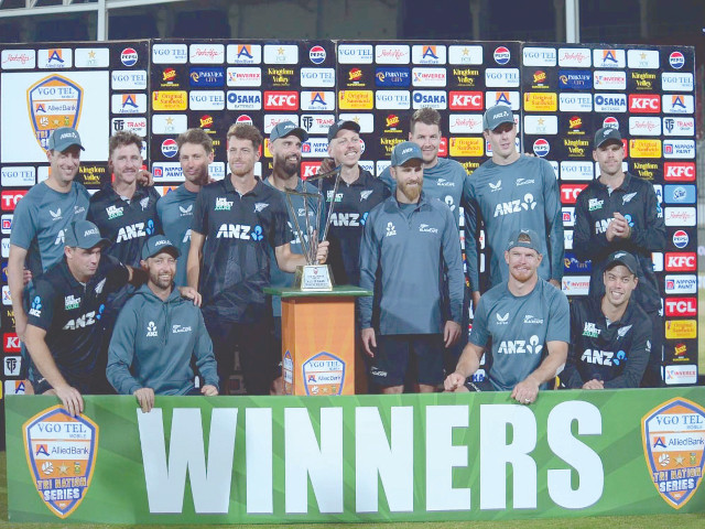 new zealand cricket team players pose with the trophy at the national bank stadium in karachi