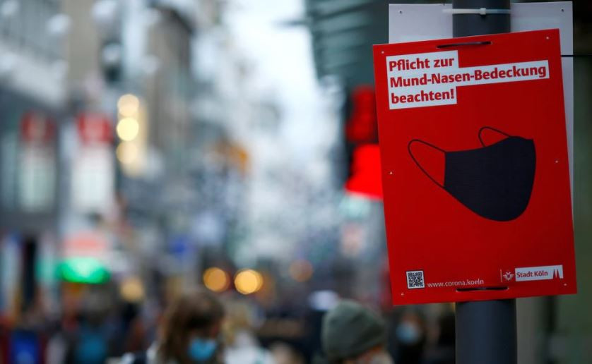 a sign that reads observe the obligation to cover your mouth and nose is placed on hohe strasse shopping street as the spread of the coronavirus disease covid 19 continues in cologne germany december 1 2021 photo reuters