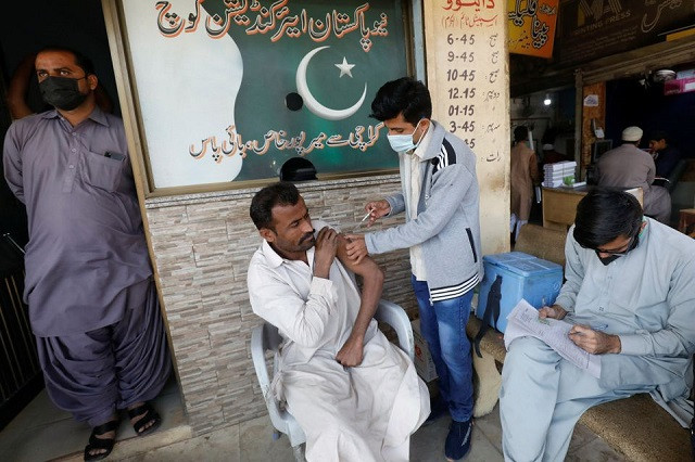 a man receives a dose of the coronavirus disease covid 19 vaccine at a market in karachi pakistan december 16 2021 reuters akhtar soomro