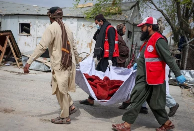 red crescent volunteers carry the body of a victim who died in what the taliban said was a pakistani air strike on a drug rehabilitation hospital in kabul afghanistan photo reuters