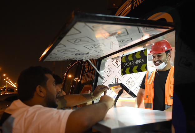 Owner of One Way Burger serves customers. PHOTO: AFP