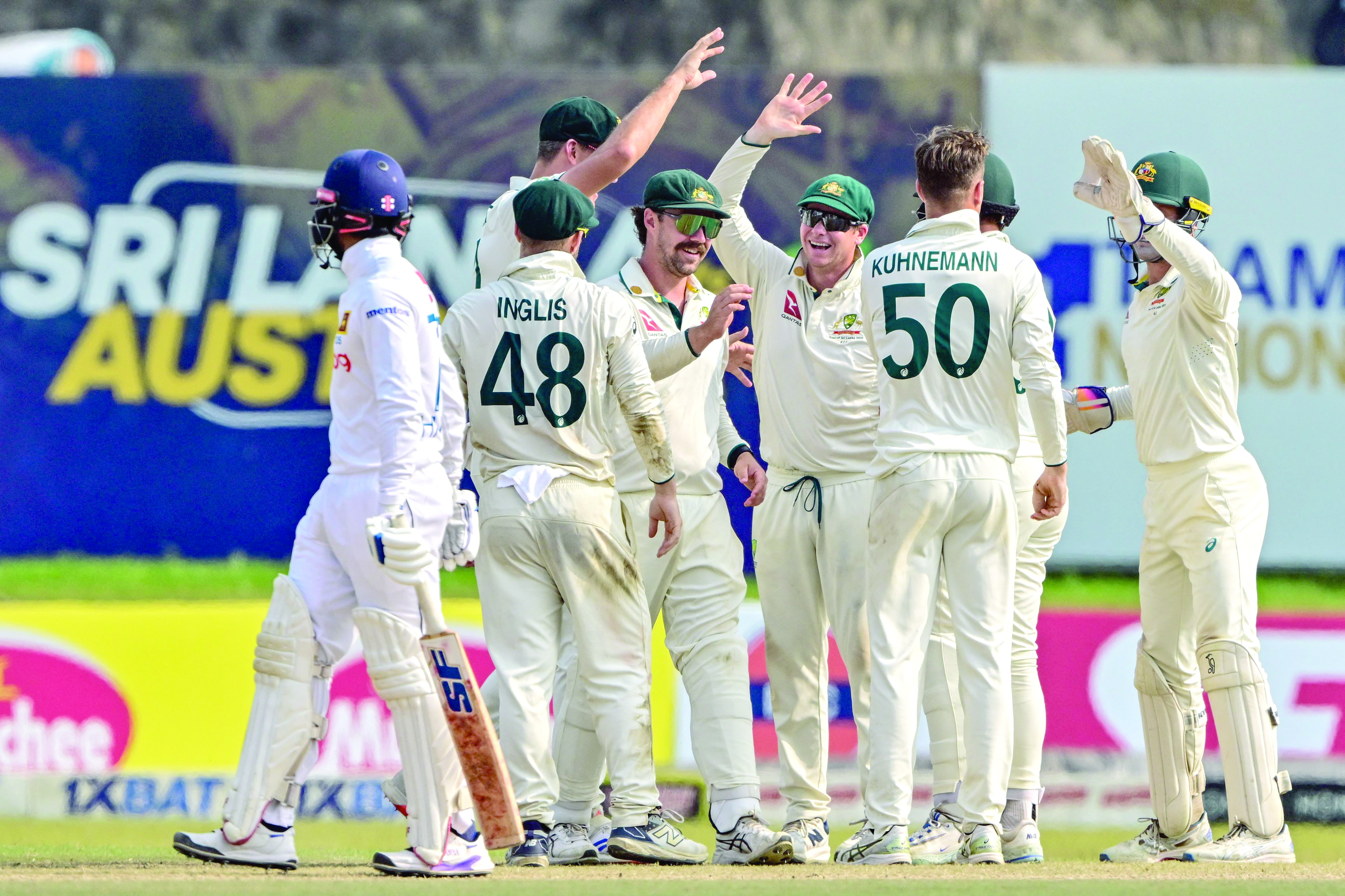 australia s captain steve smith 3r celebrates with teammates after the dismissal of sri lanka s captain dhananjaya de silva l on the third day of the second test at galle photo afp